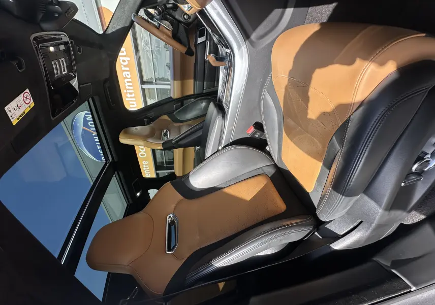 Vue intérieure du Range Rover Sport SVR 2020, sièges sport cuir bicolore camel et noir, tableau de bord moderne et toit panoramique.