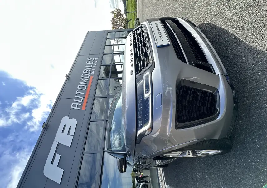 Vue 3/4 avant droit du Range Rover Sport gris foncé, mettant en valeur sa calandre et ses phares LED distinctifs.