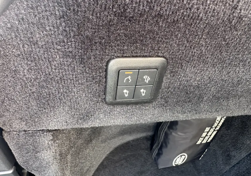 Boutons de commande du hayon électrique sur revêtement gris foncé dans le coffre d'un Range Rover Sport II V8 5.0 Supercharged SVR Carbon Edition 2020.