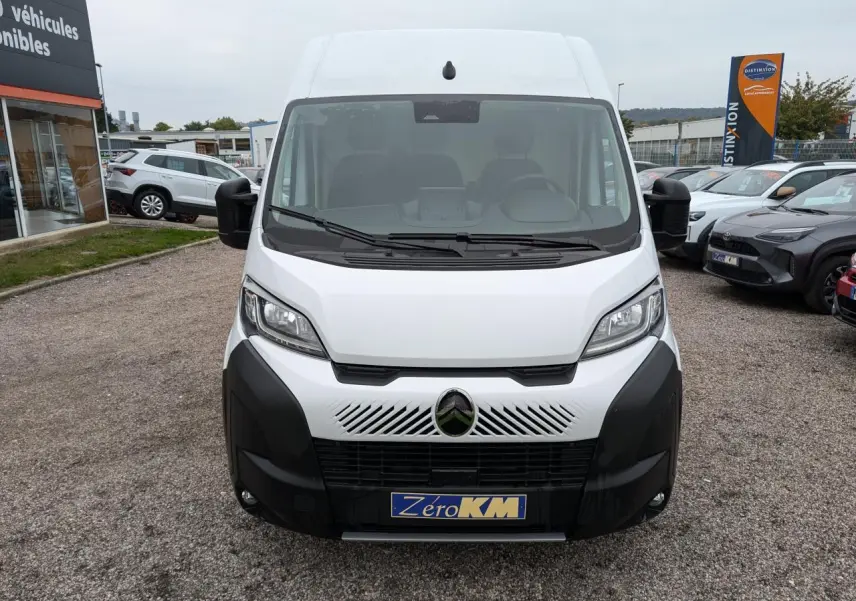 Vue de face d'un utilitaire blanc Citroën Jumper 2025 avec pare-chocs noir et logo Citroën distinctif au centre.