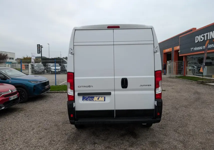 Vue arrière d'un utilitaire Citroën Jumper blanc avec portes battantes et feux rouges verticaux.