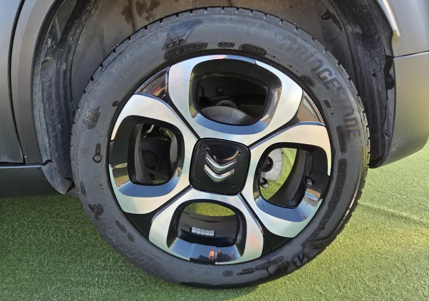 Gros plan sur la roue arrière droite d'une Citroën C3 Aircross gris platinium avec jante alliage 17'' damantée.