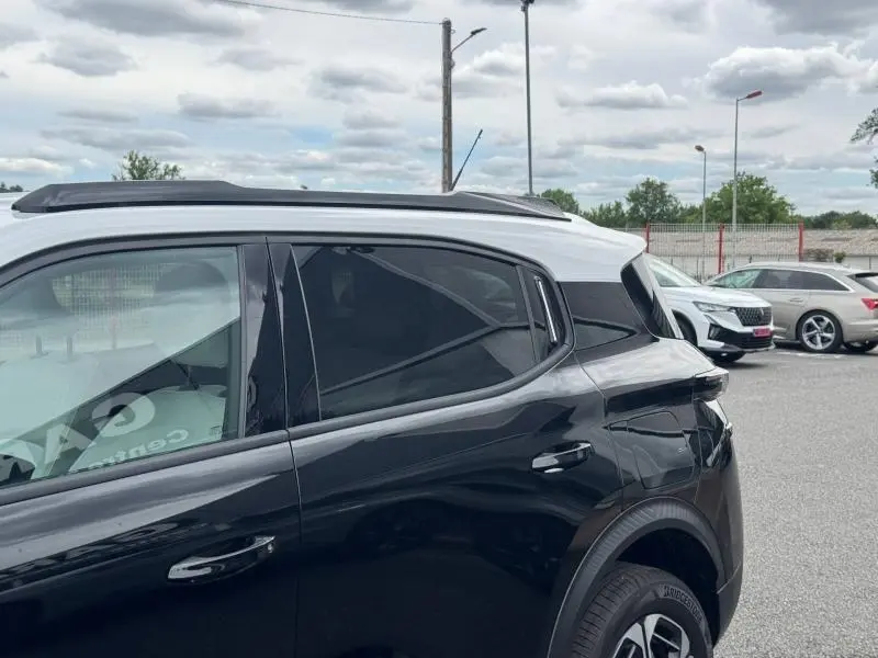 Vue latérale arrière droite du Citroën C3 Aircross noir Perla Nera avec toit blanc Opale et vitres arrière teintées.
