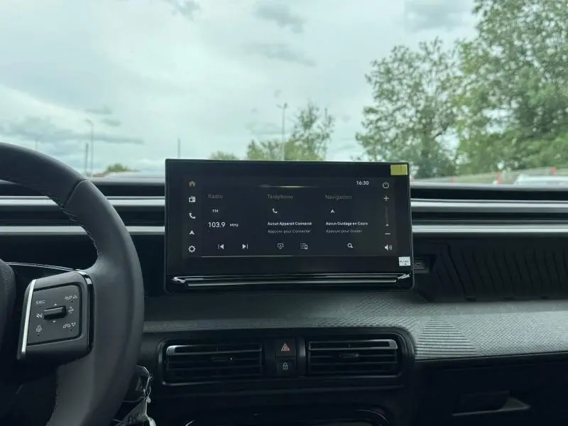 Vue intérieure centrée sur l’écran tactile du tableau de bord de la Citroën C3 Aircross 2026, volant partiellement visible.