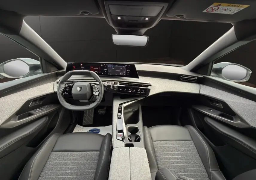 Vue intérieure avant du Peugeot 3008 blanc 2025, volant cuir multifonctions et tableau de bord numérique panoramique.