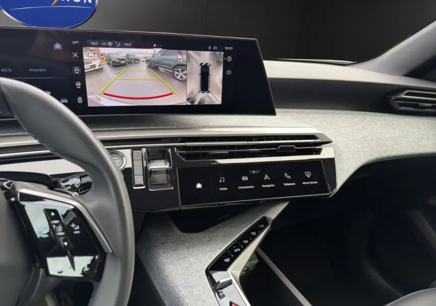 Vue intérieure du tableau de bord du Peugeot 3008 blanc, avec écran tactile affichant la caméra de recul et commandes modernes.