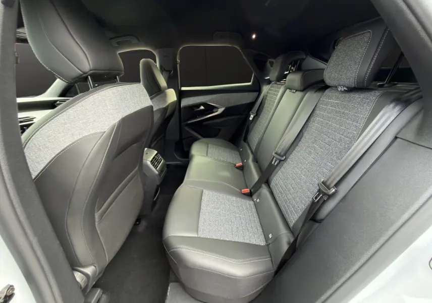Vue intérieure arrière côté gauche du Peugeot 3008 blanc, sièges en cuir et tissu gris avec ceinture de sécurité.