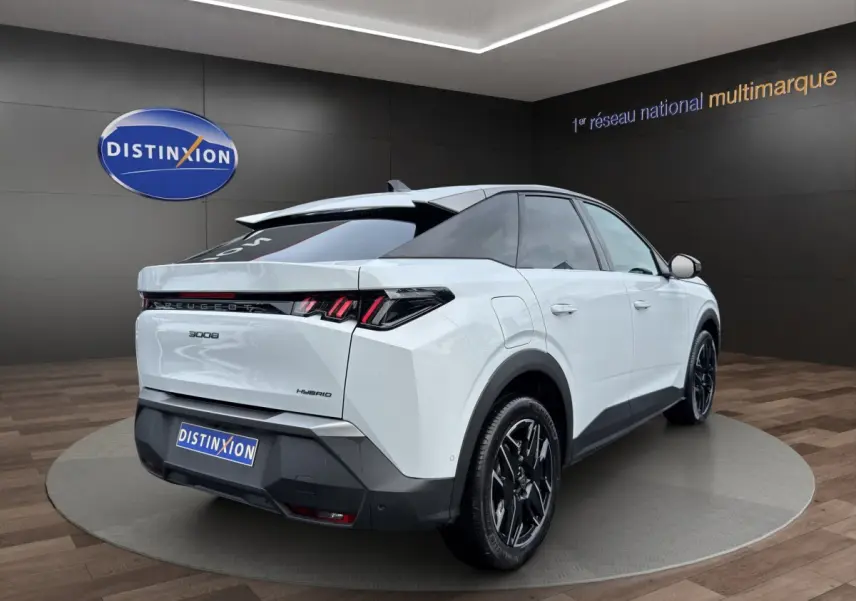 Vue 3/4 arrière droite du Peugeot 3008 blanc hybride avec feux arrière LED et jantes noires distinctives.