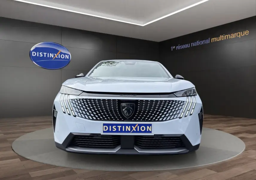 Vue frontale d'un Peugeot 3008 blanc avec calandre noire à motif géométrique et feux LED verticaux distinctifs.