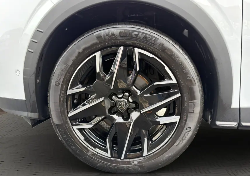 Gros plan sur la roue avant droite du Peugeot 3008 blanc, jante alliage noire et chromée avec pneu Michelin.