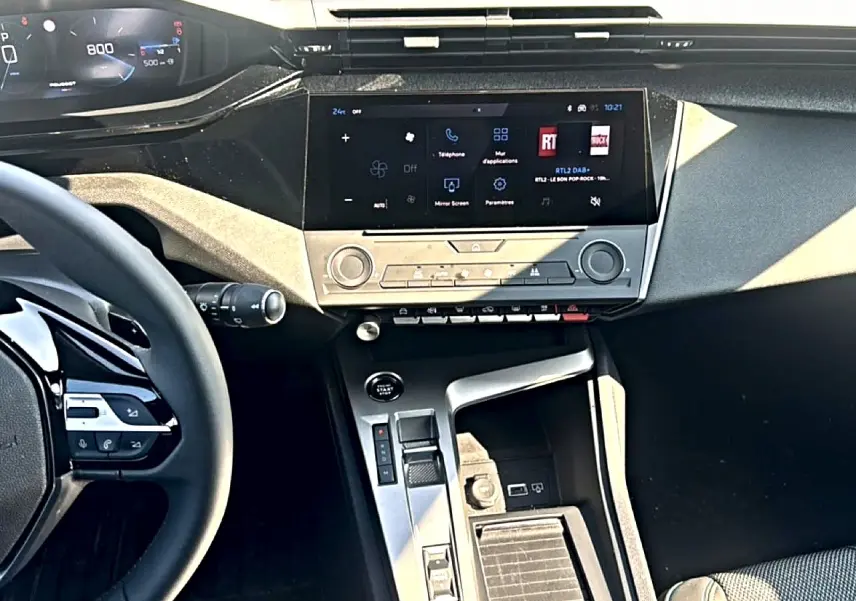 Vue intérieure de face du tableau de bord et console centrale de la Peugeot 308 gris, avec écran tactile et volant multifonction.