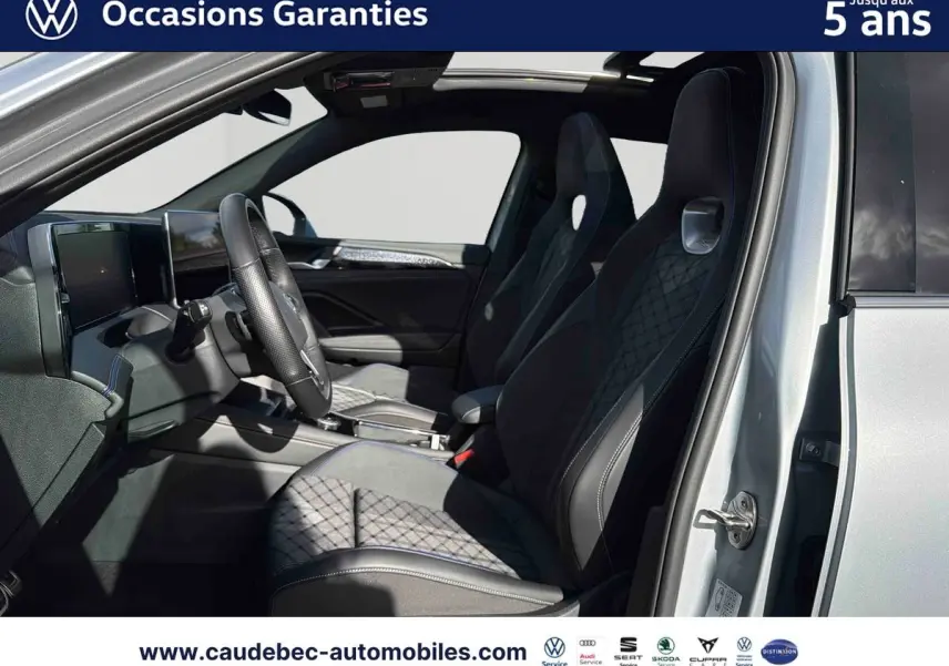 Vue intérieure côté conducteur du Volkswagen Tiguan argent Dolomite 2025 avec sièges sport et toit ouvrant panoramique.