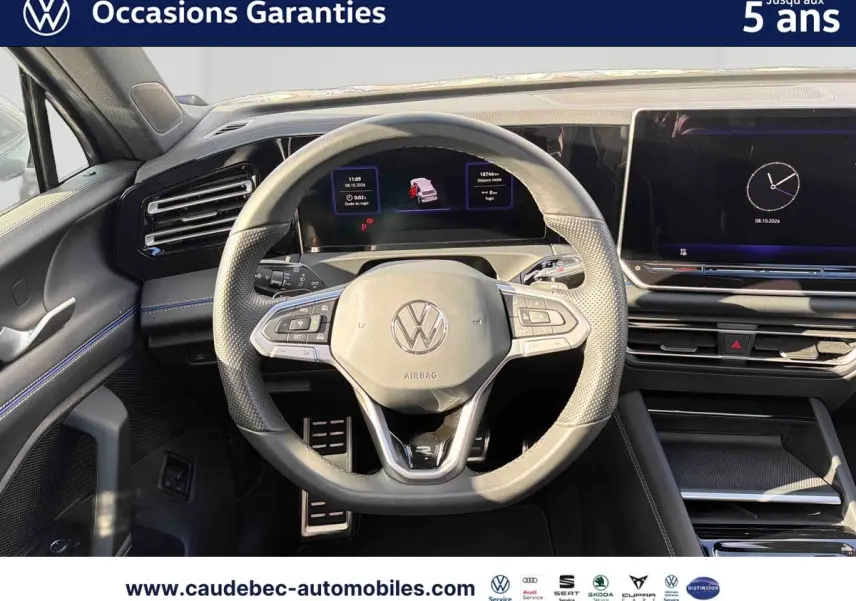 Vue intérieure centrée sur le volant multifonction cuir du Volkswagen Tiguan eHybrid 2025 avec tableau de bord digital.