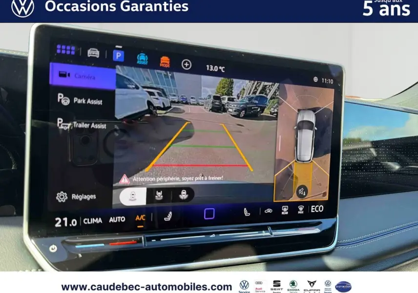 Écran tactile intérieur du Volkswagen Tiguan 2025 montrant l'assistance au stationnement avec vue caméra et vue périmétrique.