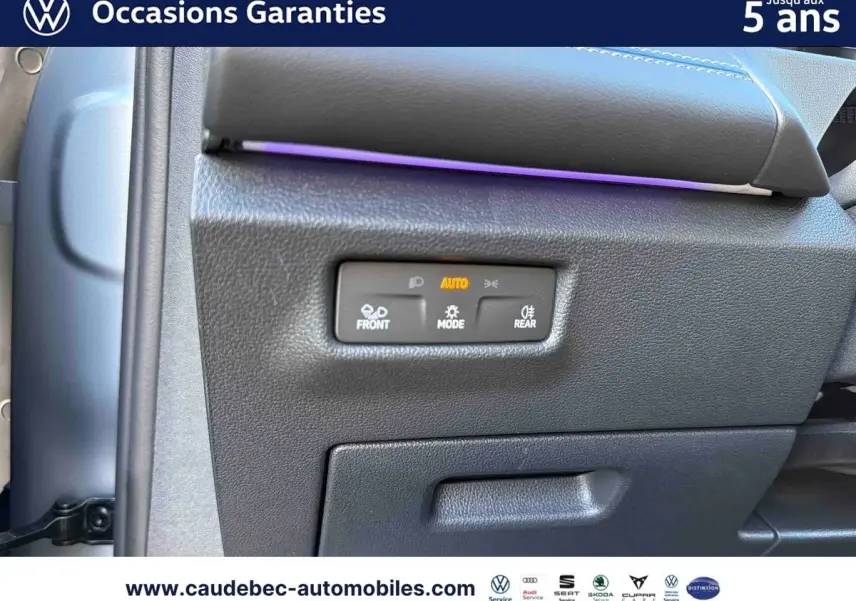 Détail du tableau de bord du Volkswagen Tiguan 2025 avec commandes d'éclairage et bandeau lumineux violet.
