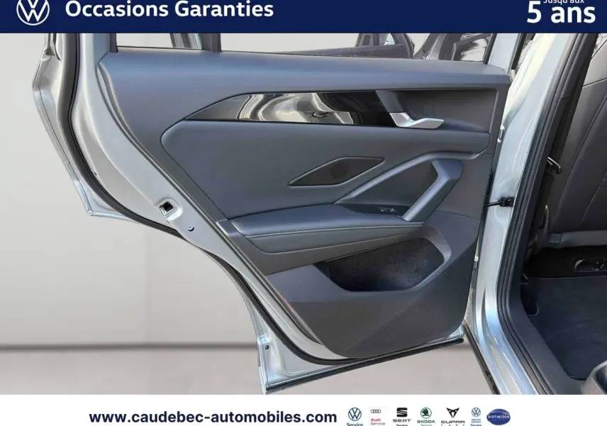 Porte arrière gauche ouverte d’un Volkswagen Tiguan 1.5 eHybrid 2025 couleur argent Dolomite, intérieur noir et garnitures modernes.