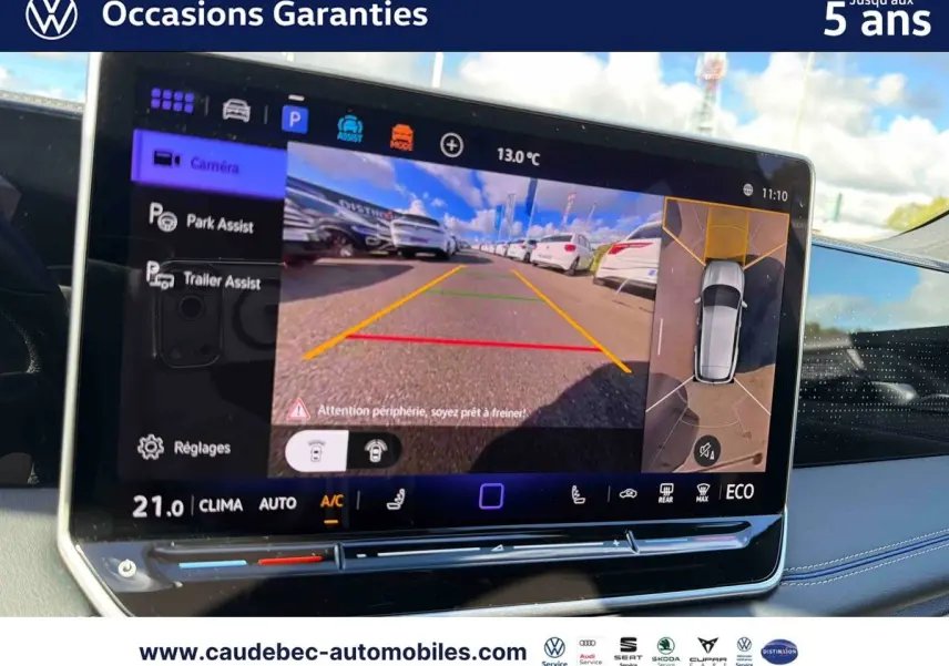 Écran tactile intérieur affichant la caméra de recul et l'assistance au stationnement du Volkswagen Tiguan eHybrid argent.