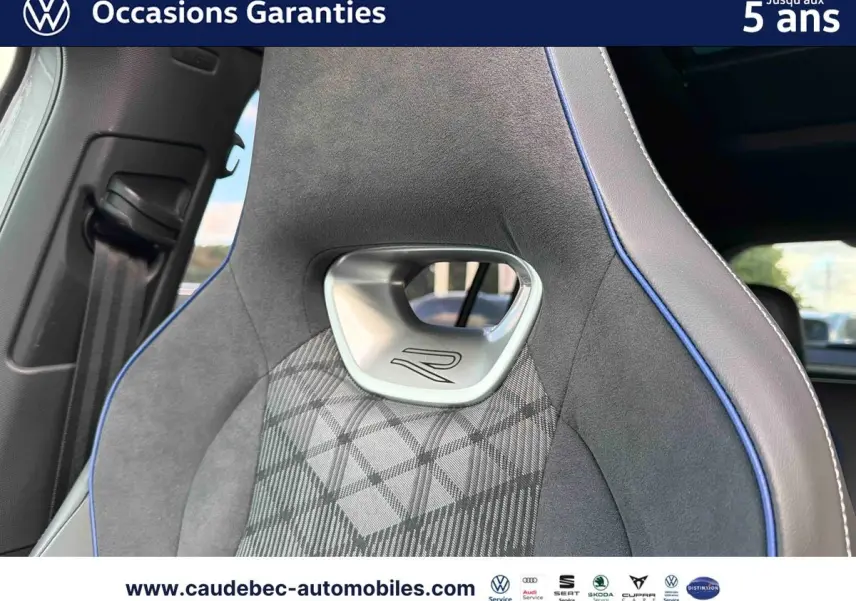 Gros plan sur le siège avant sport gris avec surpiqûres bleues et logo R du Volkswagen Tiguan 2025.