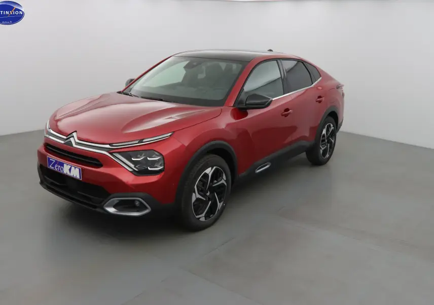 Citroën C4 X rouge Elixir métal vue 3/4 avant droit, soulignant ses lignes fluides et ses jantes bicolores.