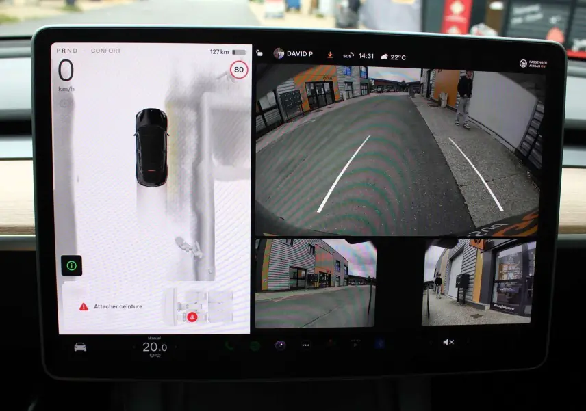 Écran central de Tesla Model Y noir métal 2024 montrant la caméra de recul et l'affichage de conduite assistée.