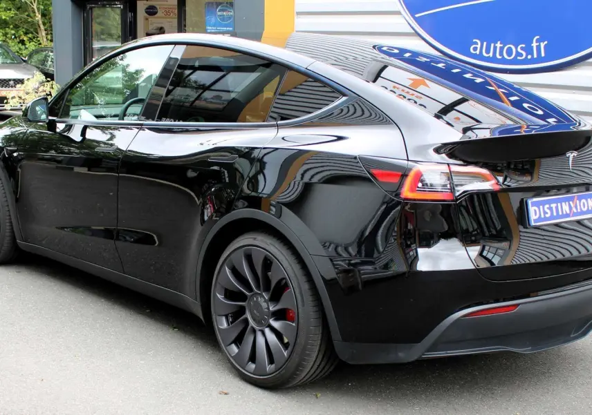 Tesla Model Y Performance noir métal vue 3/4 arrière droit, jantes noires et feux arrière LED distinctifs.