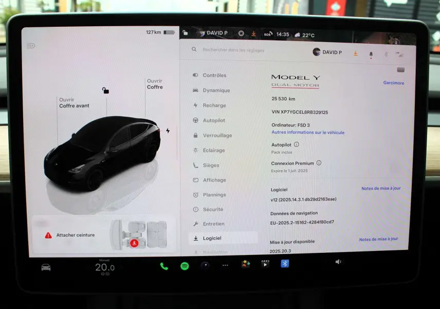 Écran tactile intérieur montrant la Tesla Model Y noire métal en vue 3/4 avant avec options et informations du véhicule.