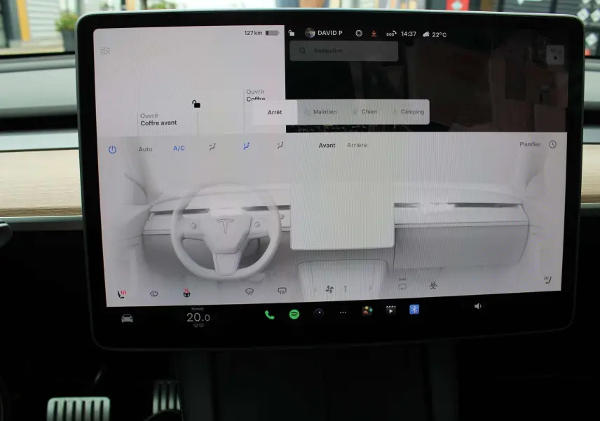 Écran tactile central de la Tesla Model Y 2024, affichant la commande de climatisation et la navigation.