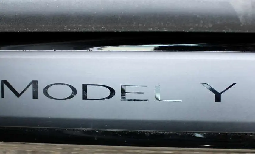 Gros plan sur la plaque noire métallisée avec l'inscription "MODEL Y" du SUV électrique Tesla 2024.