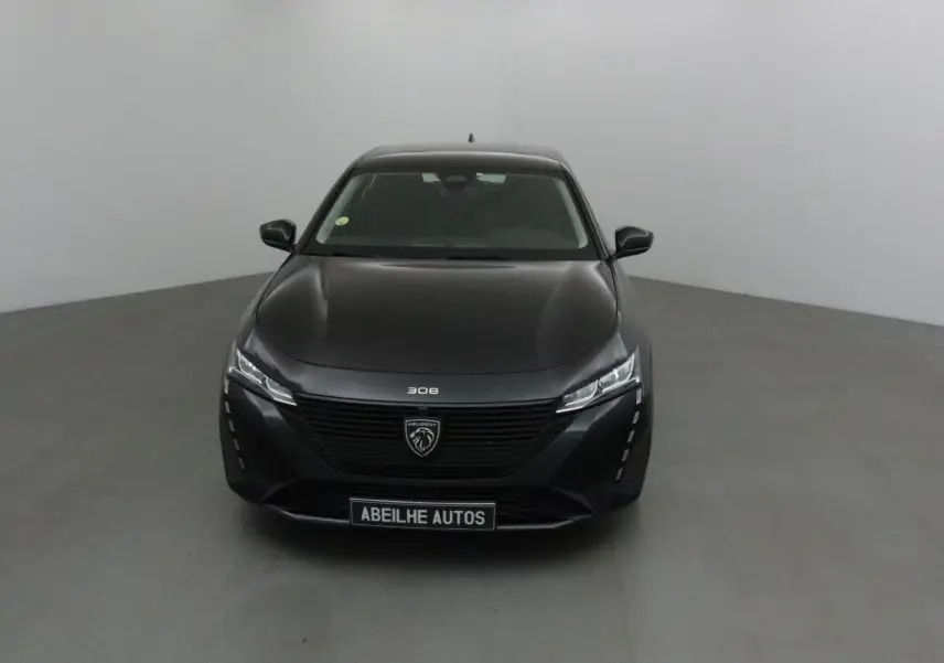 Profil côté gauche d'une Peugeot 308 noire de 2022, finition Active Pack, garée en extérieur sur un parking.