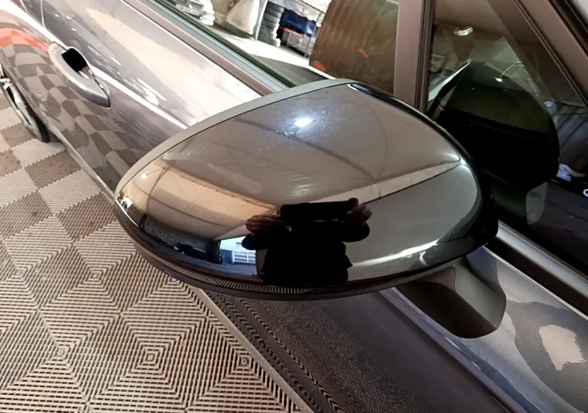 Rétroviseur côté gauche gris foncé de Renault Clio Evolution SCe 65 2022, vue rapprochée avec reflet du plafond.