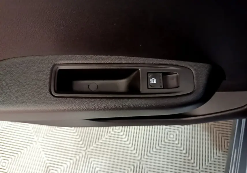 Gros plan sur la commande de lève-vitre côté conducteur de la Renault Clio gris foncé Evolution SCe 65 2022.