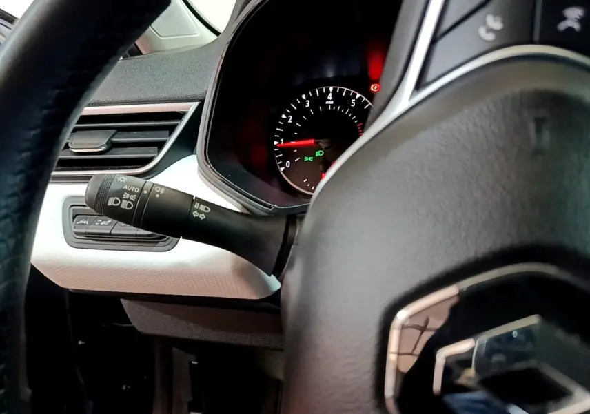 Gros plan sur le volant cuir et le compteur tachymètre de la Renault Clio gris foncé, version Evolution SCe 65, 2022.