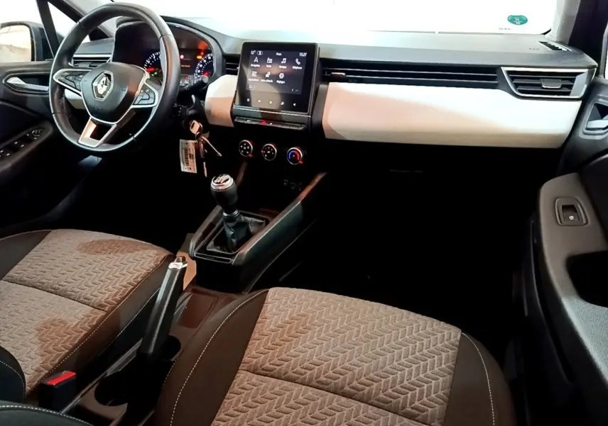 Vue intérieure avant droite de la Renault Clio Evolution SCe 65 2022, tableau de bord clair et écran tactile central.