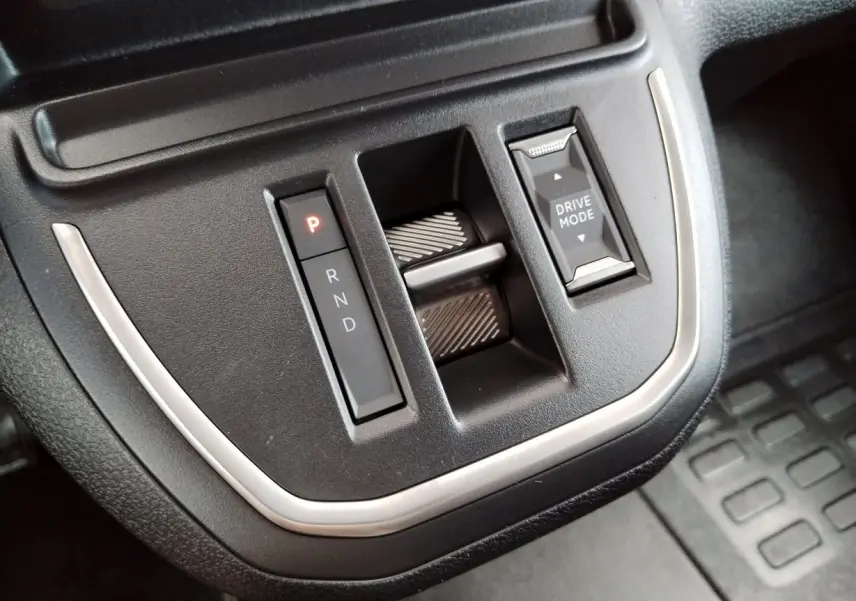 Gros plan sur la console centrale noire du Fiat Ulysse 2026, avec sélecteur de boîte auto et bouton Drive Mode.