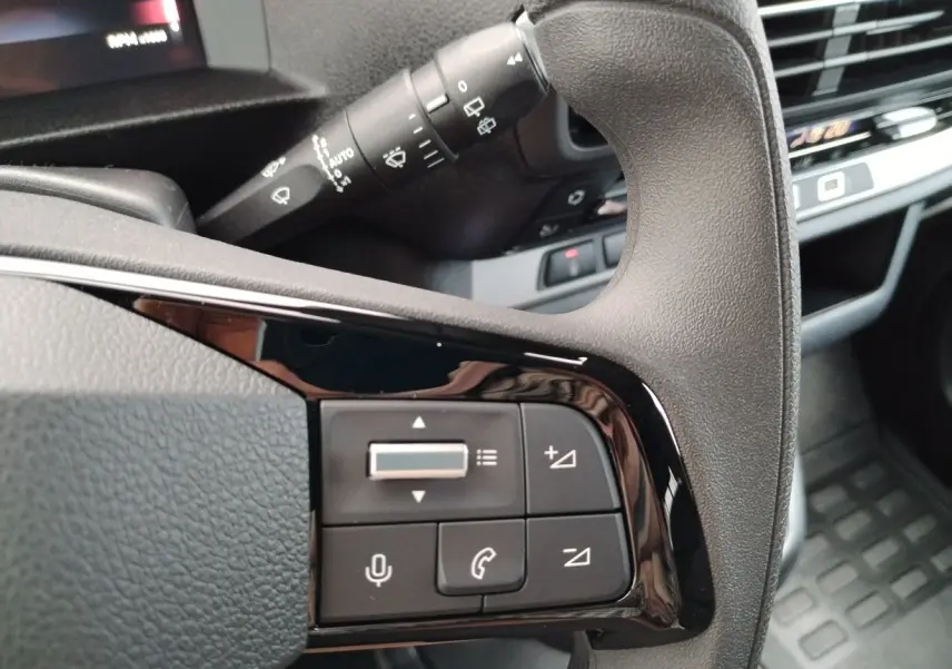 Gros plan sur les commandes noires au volant du FIAT ULYSSE XL 2026, avec levier d'essuie-glace en arrière-plan.