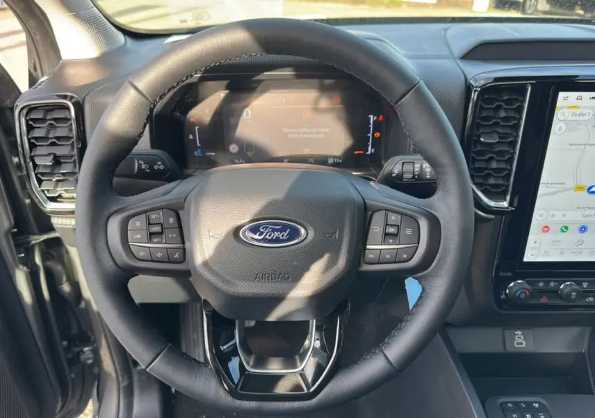 Vue rapprochée du volant cuir multifonctions et du tableau de bord numérique du Ford Ranger gris carbone 2026.