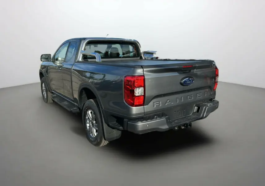 Ford Ranger gris carbone en 3/4 arrière droit avec benne couverte et arceaux inox visibles.