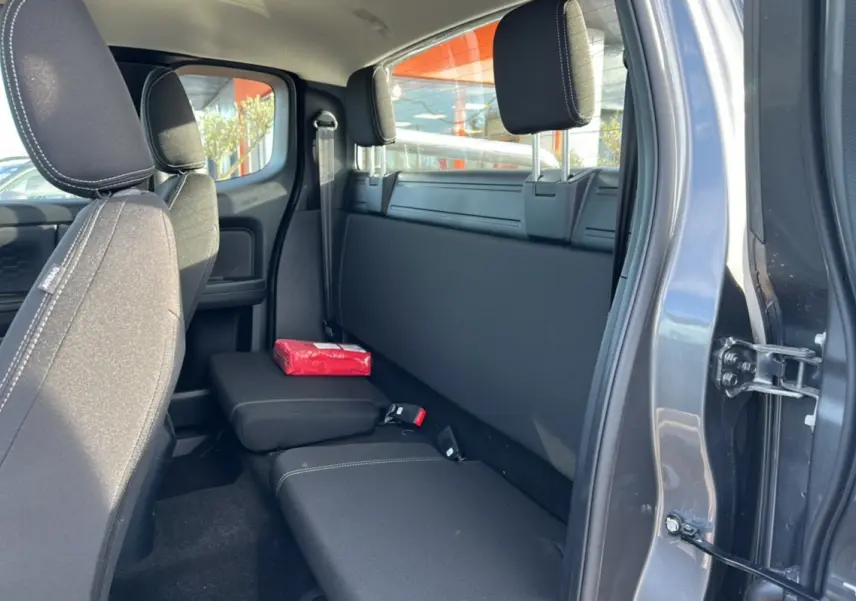 Vue intérieure côté droit sur la banquette arrière noire du Ford Ranger gris carbone avec rideau coulissant fermé.