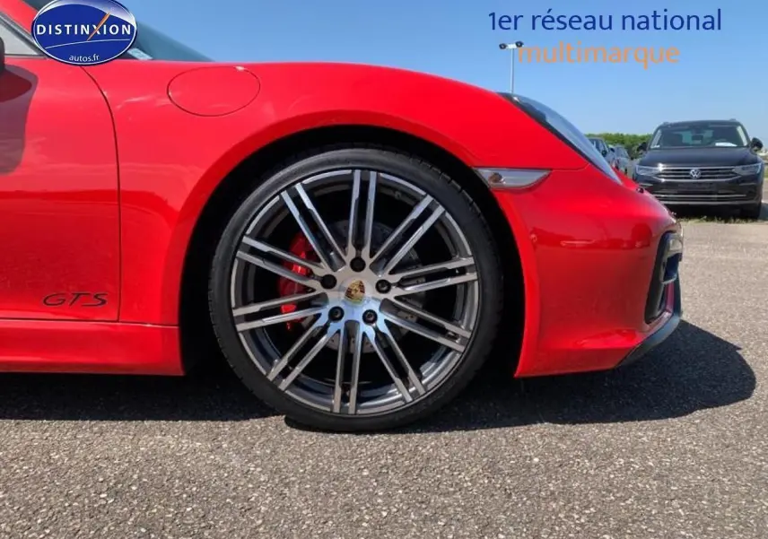 Gros plan sur la roue avant droite d'une Porsche Boxster GTS rouge avec jante alu et étrier de frein rouge.
