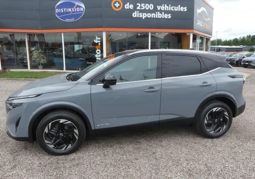 Nissan Qashqai 1.5 e-Power gris métallisé vue de profil côté gauche avec toit noir et jantes alliage noires.
