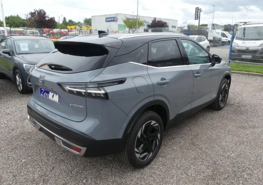 Vue 3/4 arrière droite du Nissan Qashqai 1.5 e-Power gris métallisé avec toit noir et jantes alliage 18 pouces.