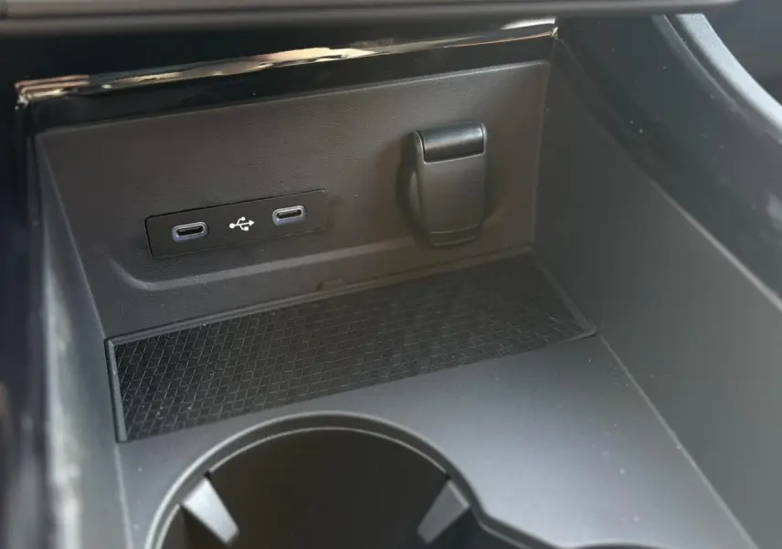 Gros plan sur la console centrale noire du Renault Rafale E-Tech avec ports USB-C et prise 12V visible