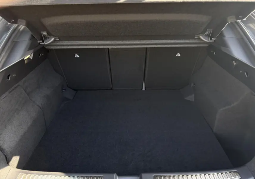 Coffre ouvert vu de l'arrière d'une Renault Rafale gris schiste, montrant l'espace de chargement vide et tapis noir.