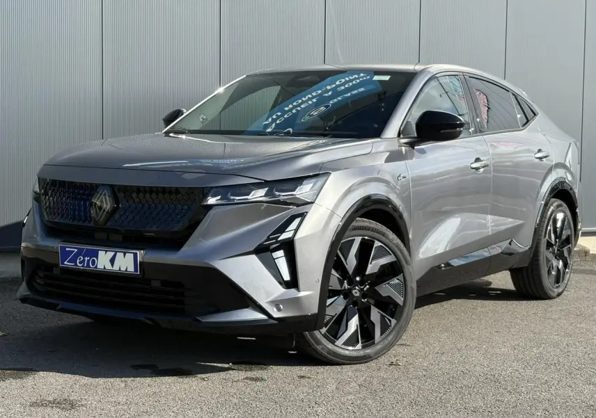 Renault Rafale E-Tech gris schiste en 3/4 avant droit avec calandre 3D et jantes noires diamantées.