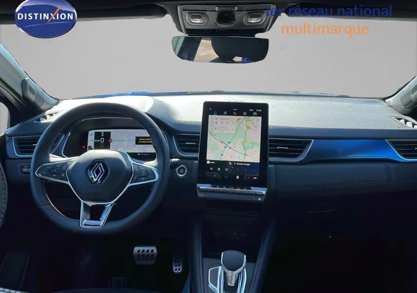 Vue intérieure frontale du tableau de bord du Renault Captur bleu Iron Metal, avec écran tactile central et volant multifonction.