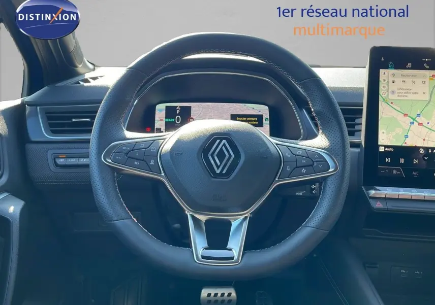 Volant en cuir perforé avec logo Renault au centre, tableau de bord numérique et écran tactile du Renault Captur hybride 2025.