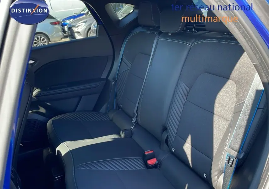 Vue intérieure sur les sièges arrière noirs avec surpiqûres bleues du Renault Captur E-Tech hybride 2025 côté droit.