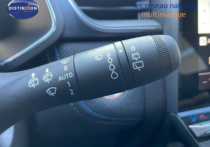 Gros plan sur la commande d'essuie-glace du Renault Captur E-Tech hybride 2025, intérieur noir avec surpiqûres bleues.