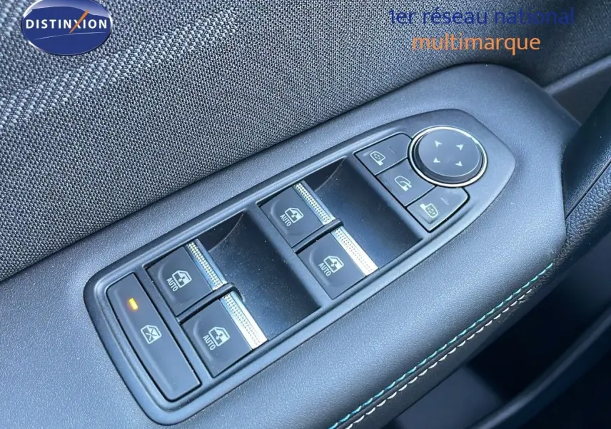 Gros plan sur les commandes des vitres électriques côté conducteur du Renault Captur E-Tech hybride 2025 avec surpiqûres bleues.