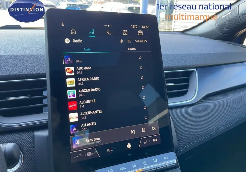 Vue intérieure centrée sur l'écran tactile du tableau de bord du Renault Captur bleu iron metal avec toit noir.